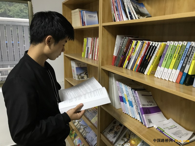 项目职工在书架前认真翻阅书籍
