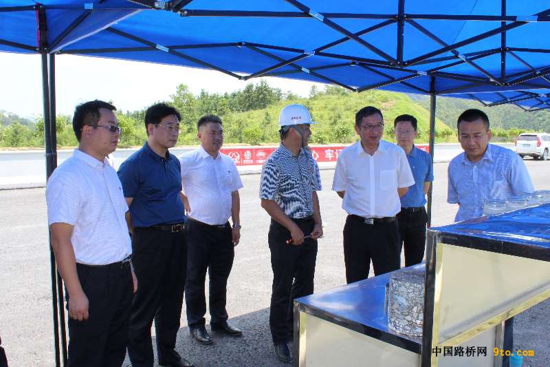 2,广东省交通建设集团董事长邓小华(右3)在察看水稳芯样及沥青材料