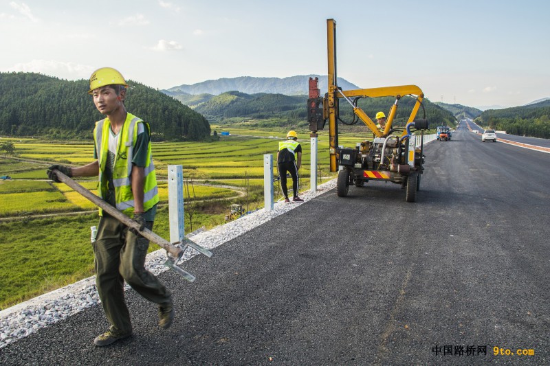 图为：兵团十一师北新路桥集团福建顺邵高速项目交安工人正在安装公路护栏立柱 雒焕鼎摄