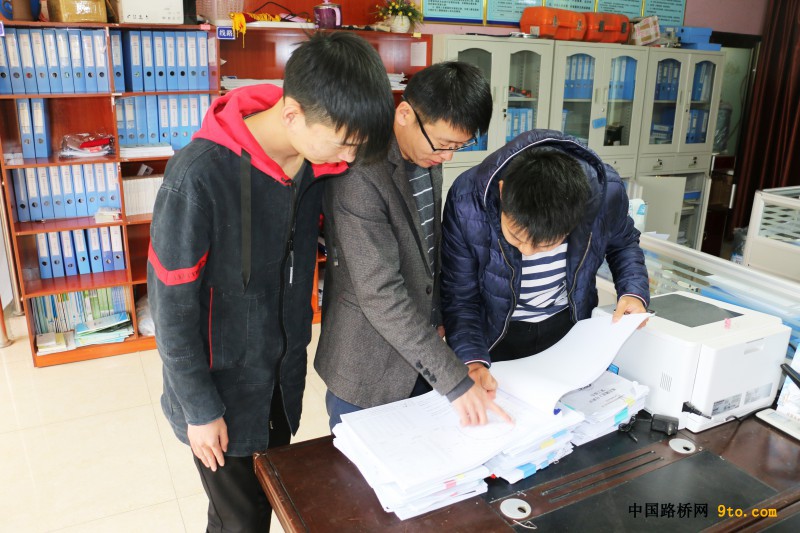 附图2：项目部工程部长为实习生讲解图纸（何钐 摄）