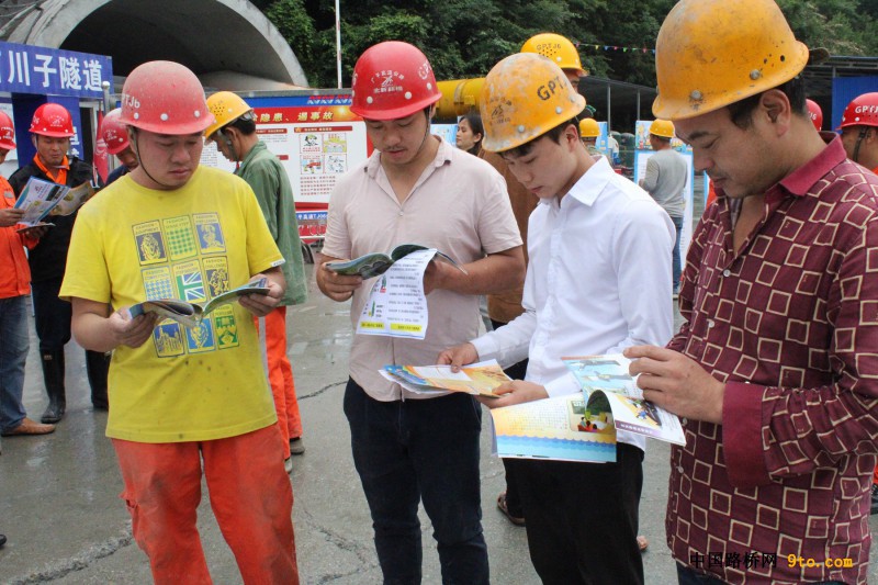 图5为广平高速项目TJ06合同段石川子隧道施工工人在翻阅《安全手册》(摄影 刘英华)